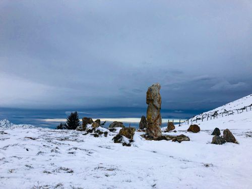 Free A serene winter landscape with snow-covered rocks and cloudy skies, ideal for nature themes. Stock Photo