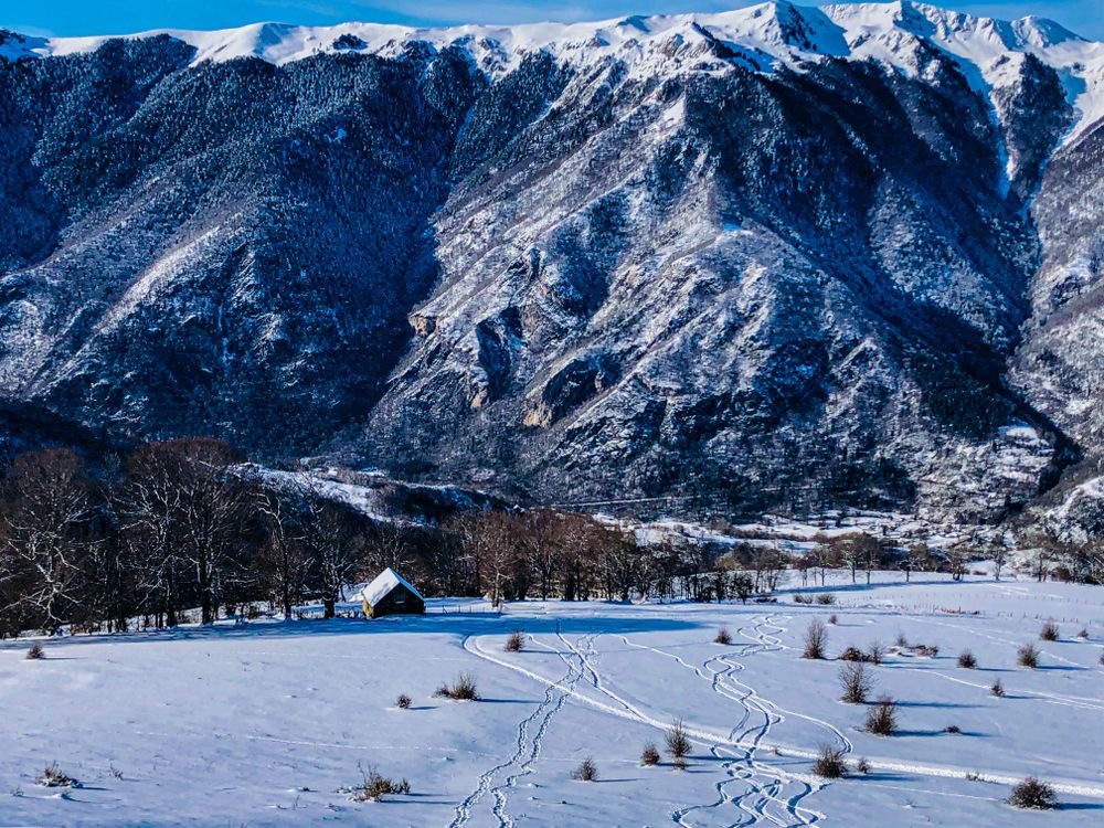 A Cabin on a Snow Covered Ground Near the Mountains · Free Stock Photo