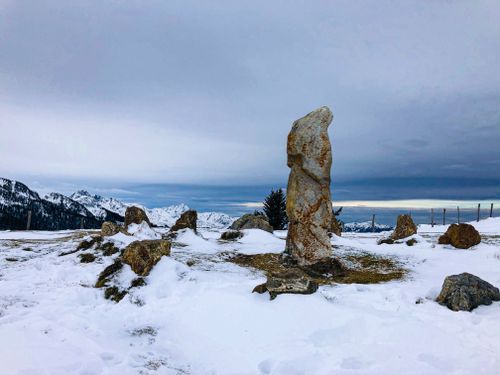 Free Serene winter mountain scene with snow-covered stones and clear sky. Stock Photo