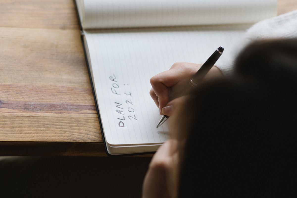 Woman writing goals and plans in a notebook