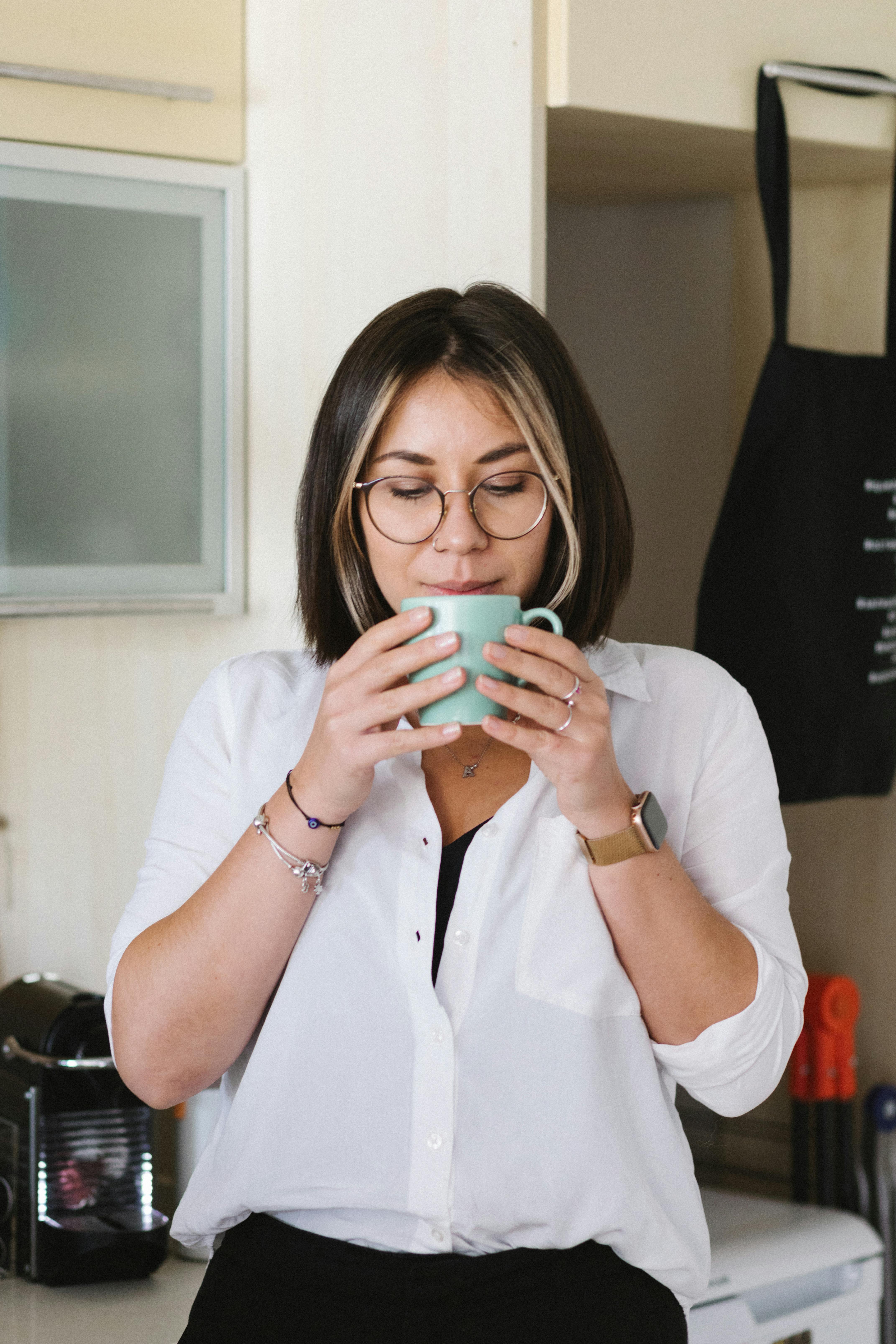 content woman drinking fresh coffee in kitchen