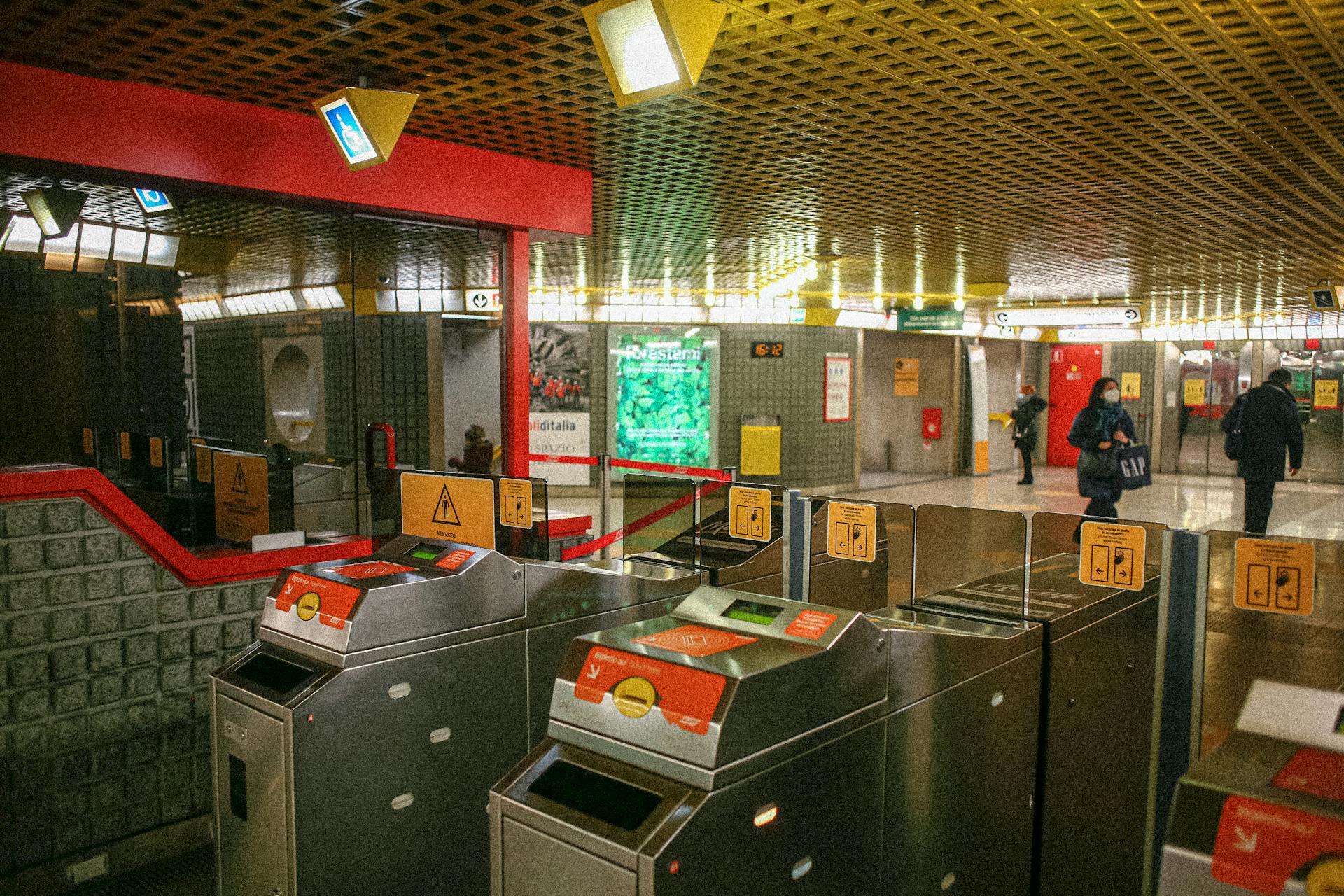 Ticket gates at a busy Milano metro station, showcasing public transit infrastructure.