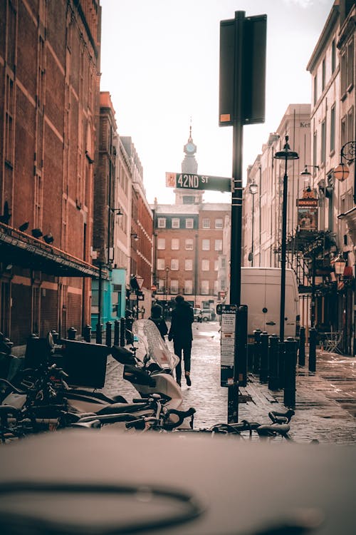 People Walking on the Street Between Buildings