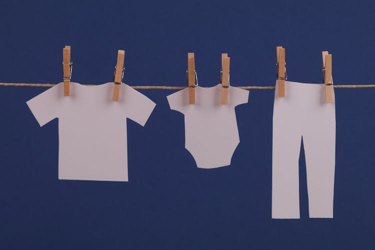 Paper Clothes Hanging On Rope On Blue Background