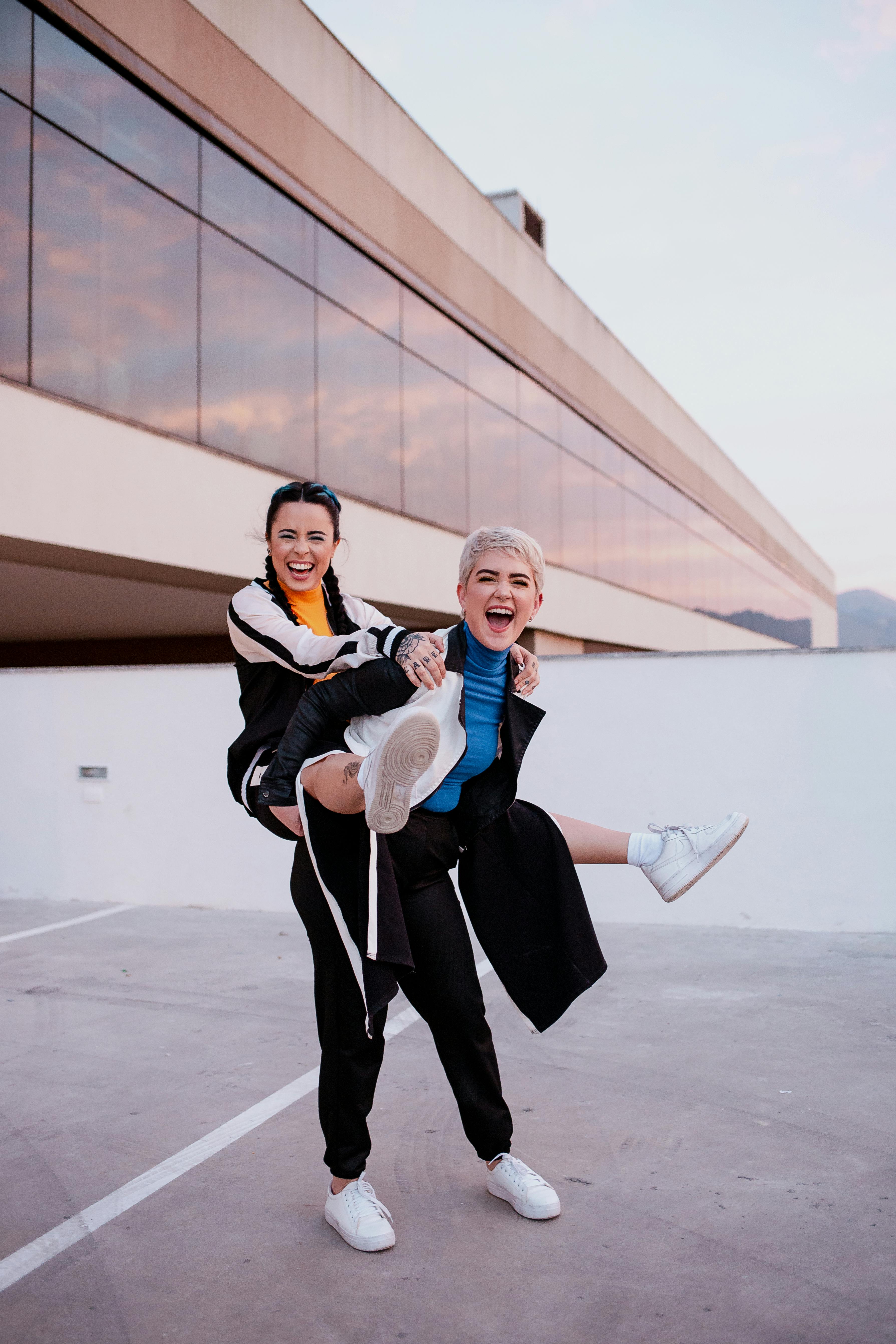 cheerful woman giving piggyback ride to happy friend