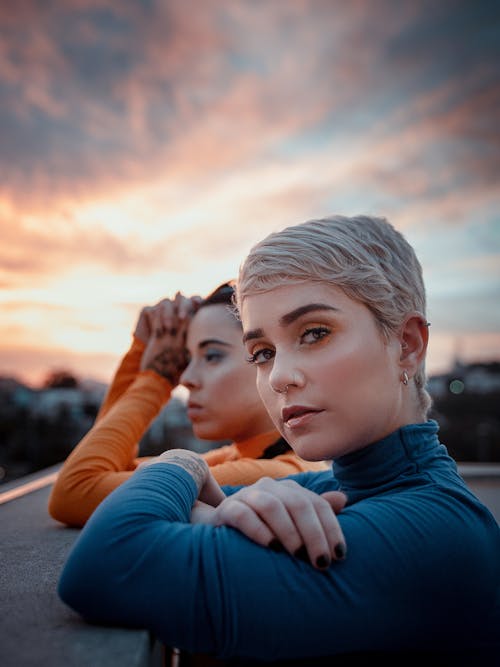 Young trendy friends leaning on concrete barrier