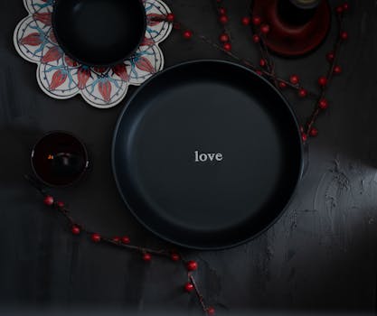 Elegant black plate with 'love' surrounded by decorative elements, perfect still life.