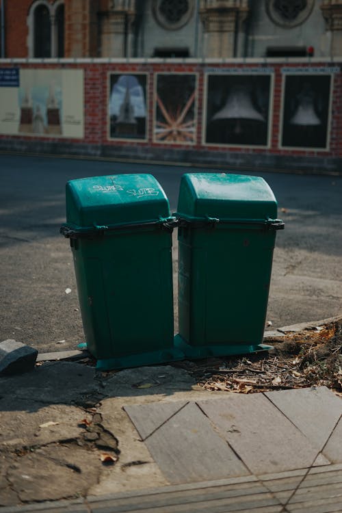 A Green Trash Bins on the Sidewalk