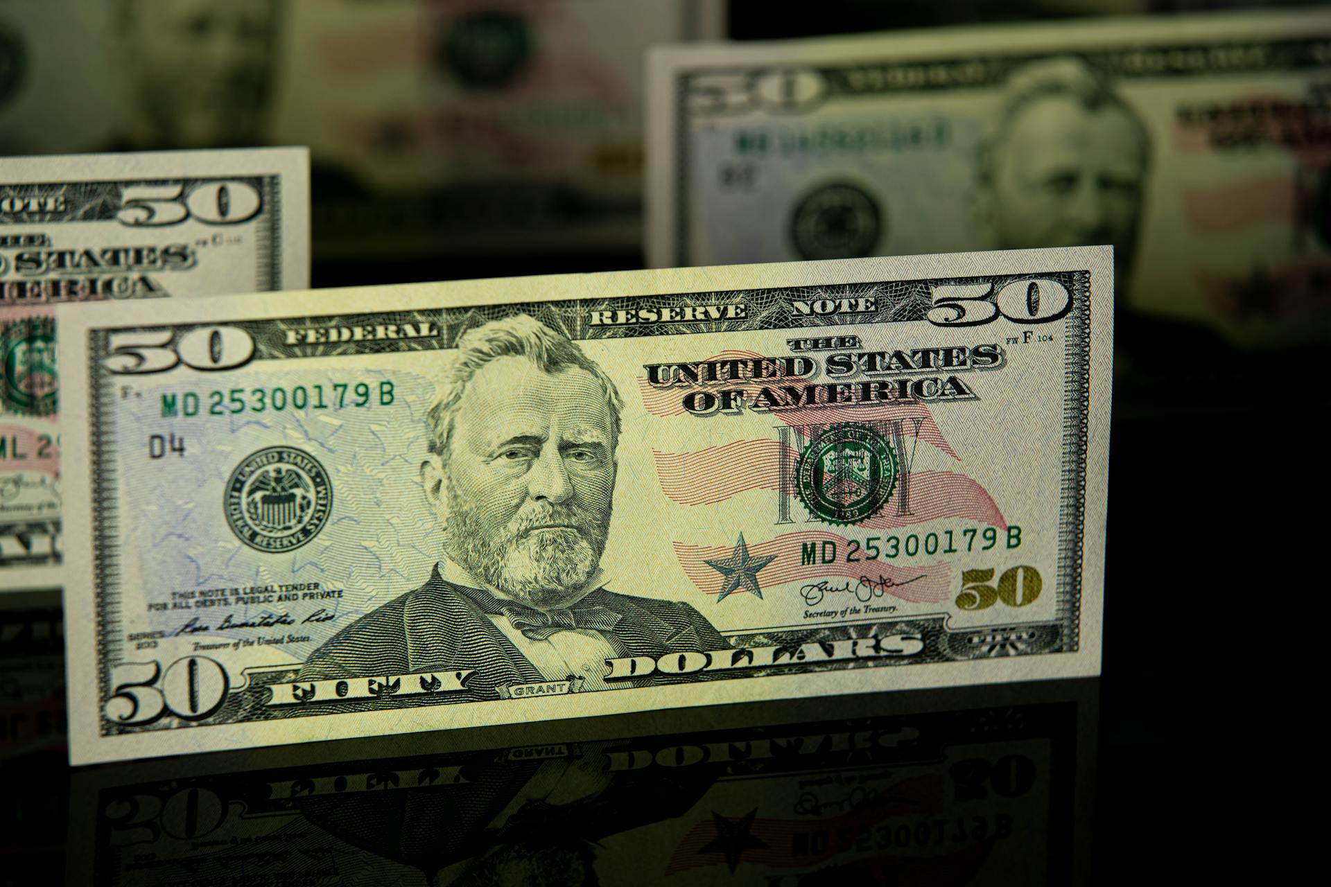 Detailed close-up of a US fifty dollar bill, emphasizing currency design and wealth theme.