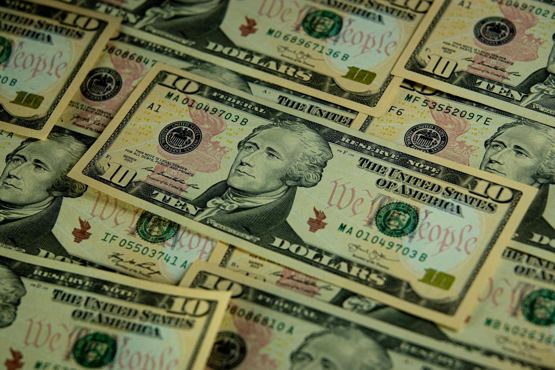 A detailed close-up of overlapping ten dollar bills showcasing American currency.