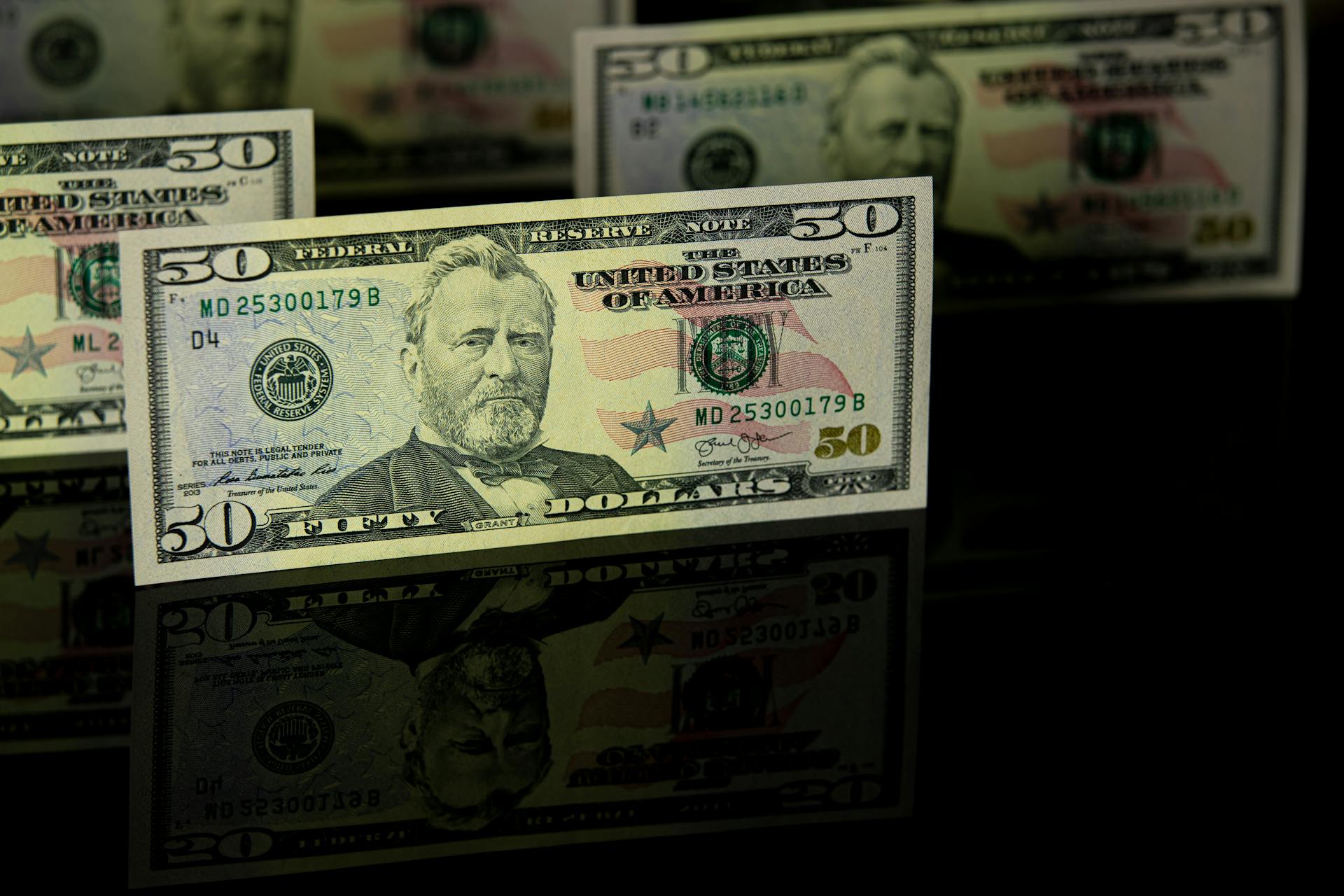 Crisp 50 dollar bill with reflection, offering a detailed view perfect for financial themes.