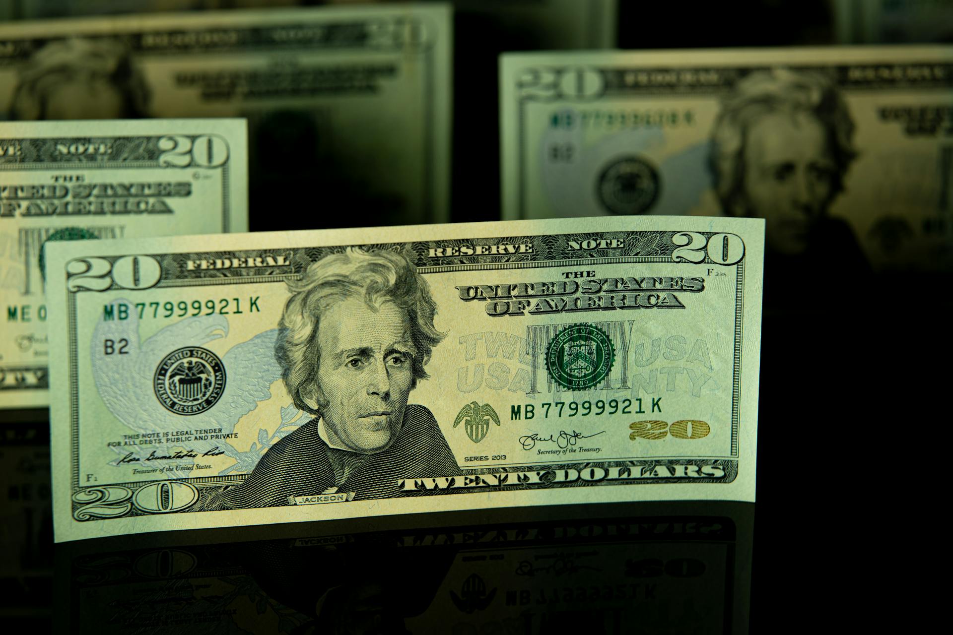 Crisp twenty dollar bill featuring Andrew Jackson against black backdrop.