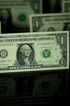Detailed shot of a US dollar bill on a reflective surface, highlighting currency design.