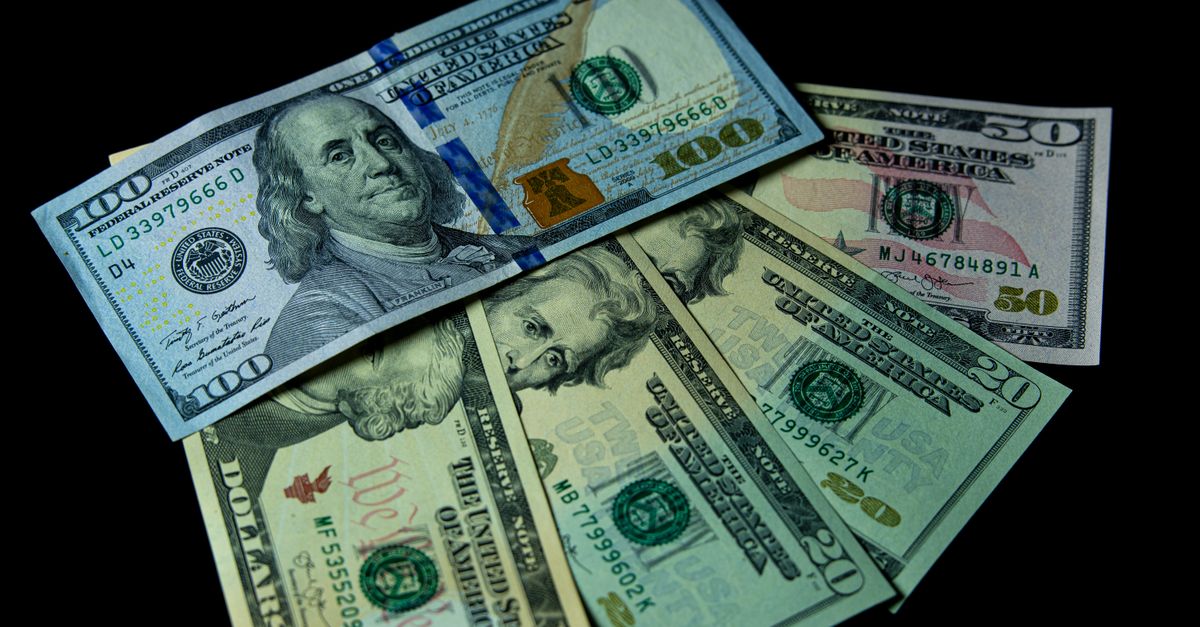 Photo by Sergei Starostin Detailed view of multiple US dollar bills against a black background, highlighting financial themes.