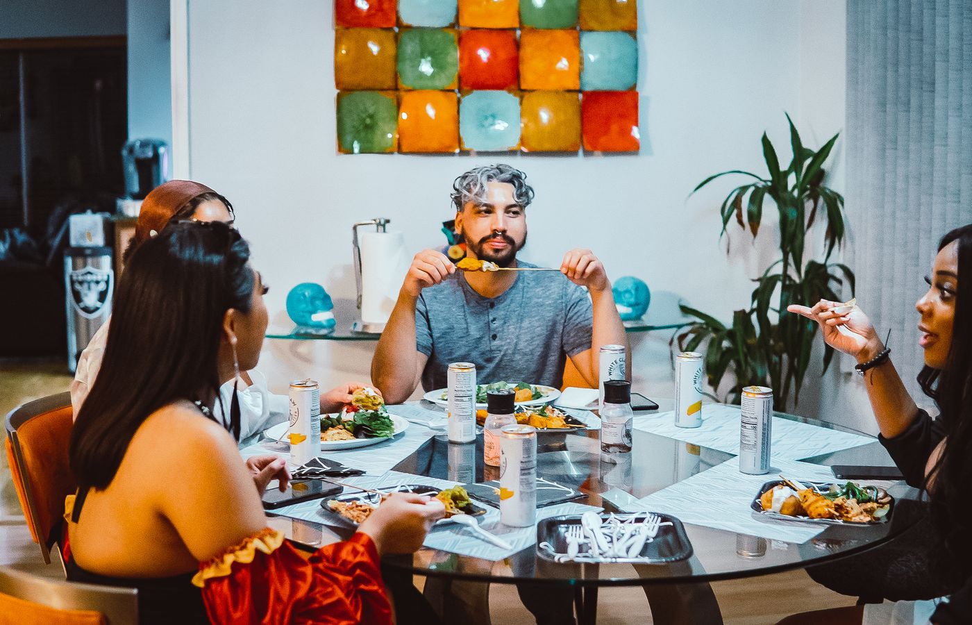 A group of friends share a lively dinner at home, enjoying food and conversation.