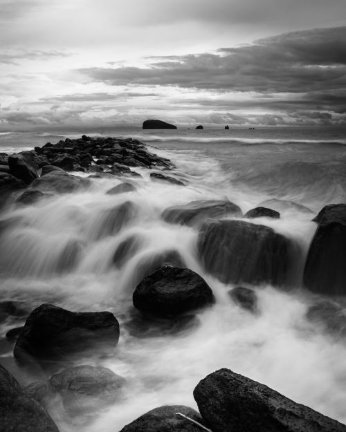 Free Capture of waves crashing onto rocks at a Bali shore in black and white, exuding a moody, dramatic tone. Stock Photo