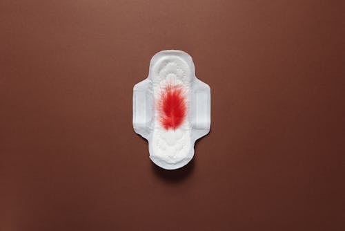 A White Menstrual Pad with Red Feather