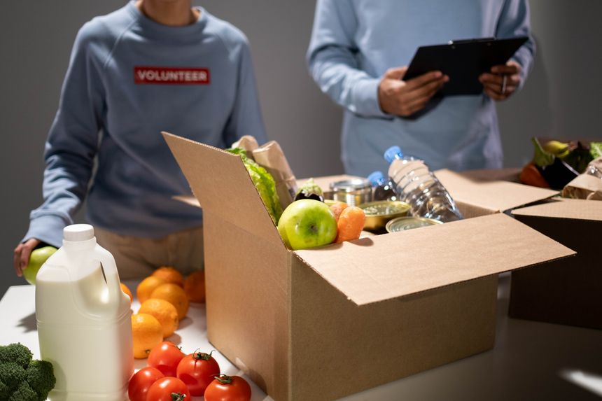 Volunteers packing a crate of fruit and vegetables for a community larder — photo by cottonbro studio on Pexels