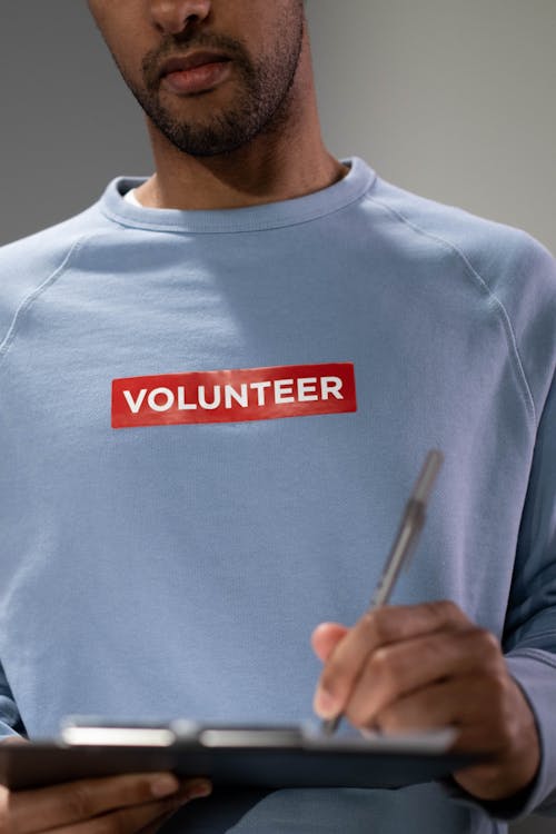 Free A Person in Blue Sweater Holding Silver Pen Stock Photo