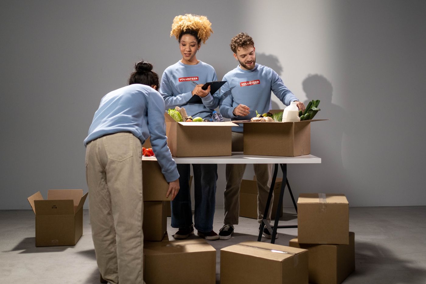 Volunteers preparing boxes of food donations for community distribution