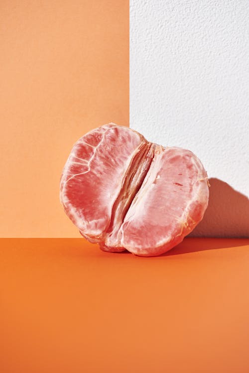Free Peeled Grapefruit on Orange Background Stock Photo