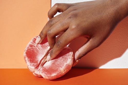 Free Person Holding Raw Meat on Orange Table Stock Photo