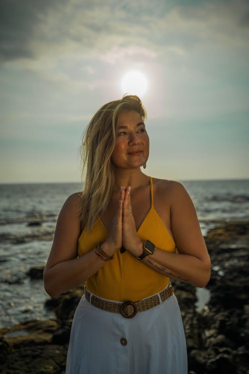 Calm woman doing surya namaskar asana on seashore