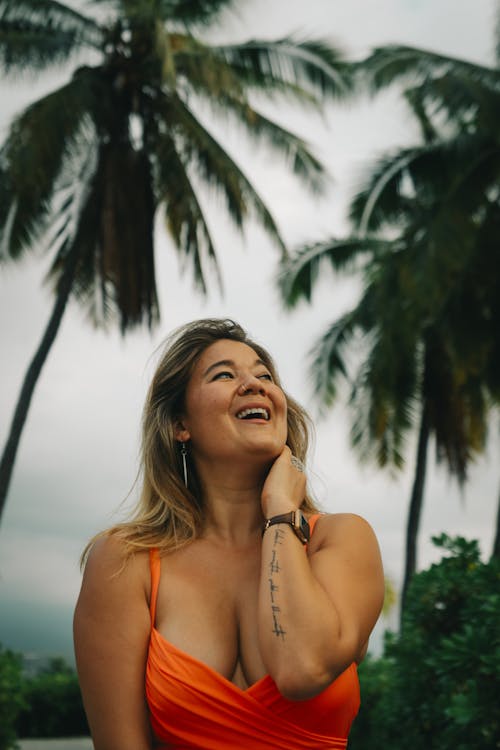 Smiling Woman Outdoors Between Palm Trees