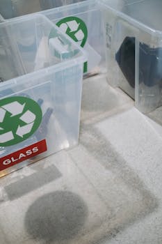 Close-up of transparent recycling bins with labels for proper waste management.