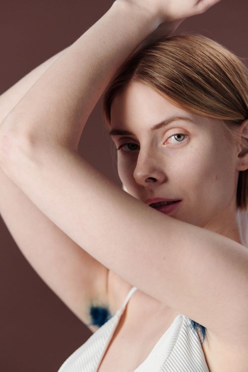 Free Close-up portrait of a young woman striking a pose with arms raised in a studio setting, highlighting elegance and beauty. Stock Photo
