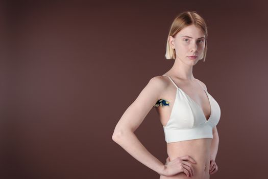 A Woman in White Brassiere Posing with Hands on Her Hips