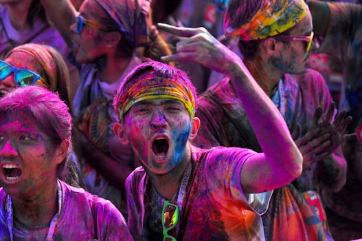 Joyful participants covered in color powder at a lively Holi festival gathering.