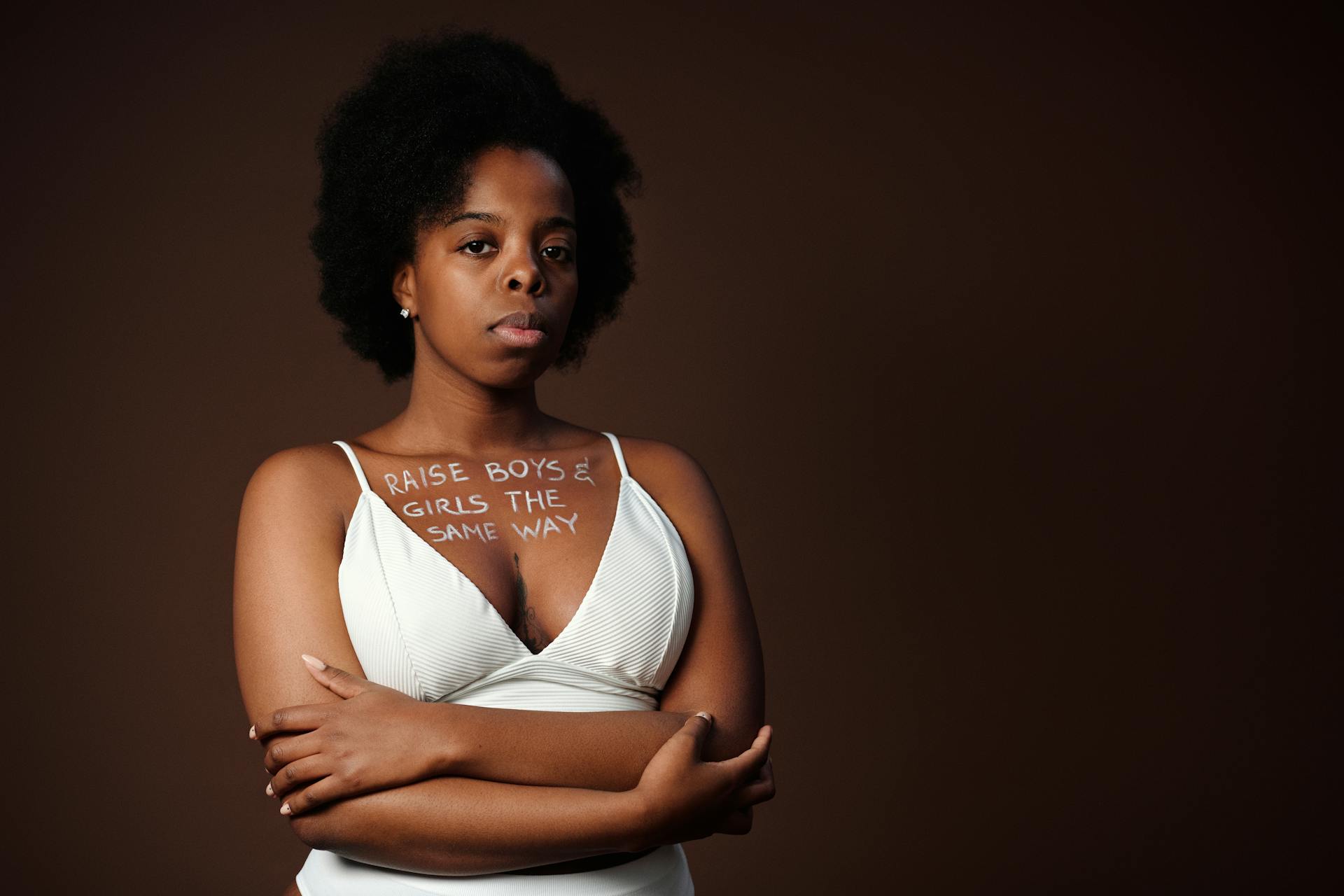 Portrait of a woman with afro hair advocating gender equality with text slogan.