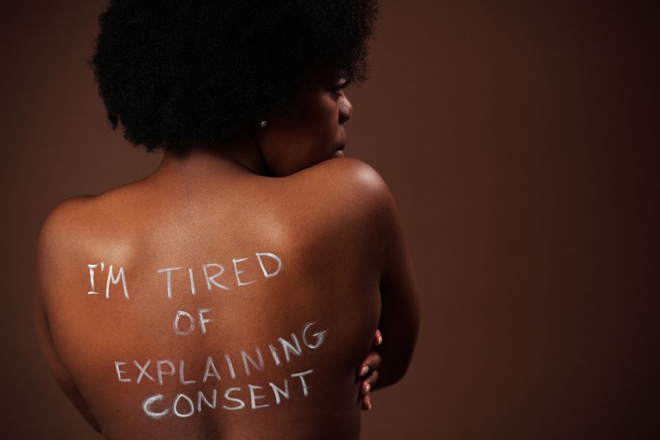 Close-up of a woman with consent message on her back, promoting awareness.