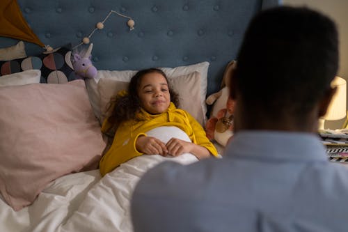 Free A Father Tucking Her Daughter to Bed Stock Photo