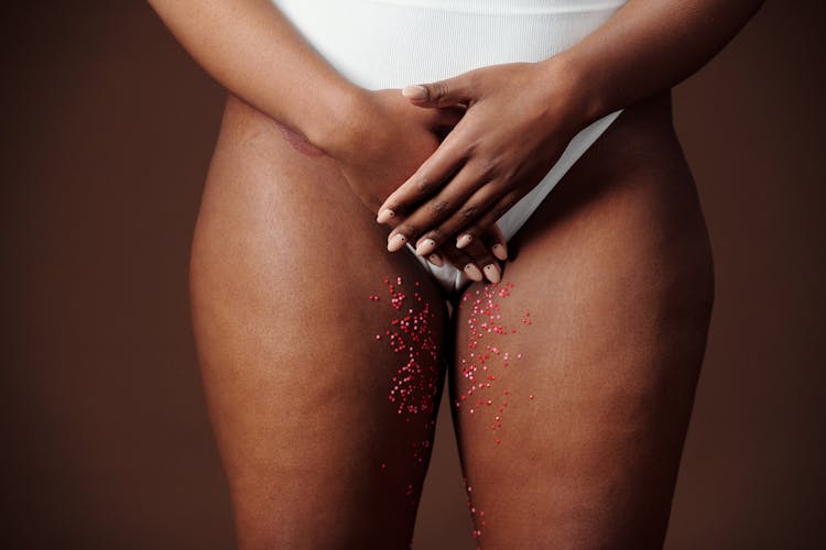 A Person Covering Her White Underwear Using Her Hands