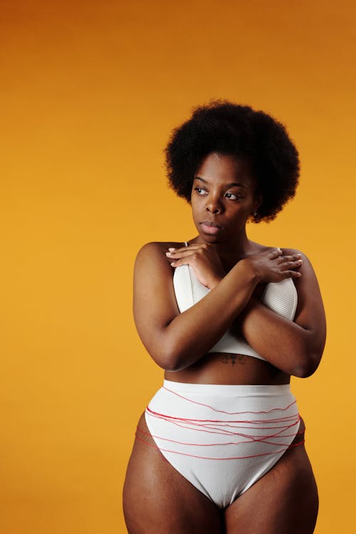 Free A Woman in White Underwear with Red Thread with Her Hands on Her Chest Stock Photo