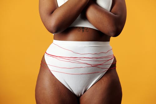 Free Body of Woman with Red Thread Wrapped Around Abdominal Area Stock Photo
