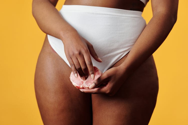 Close-up Of Woman In White Underwear Holding Pomelo 