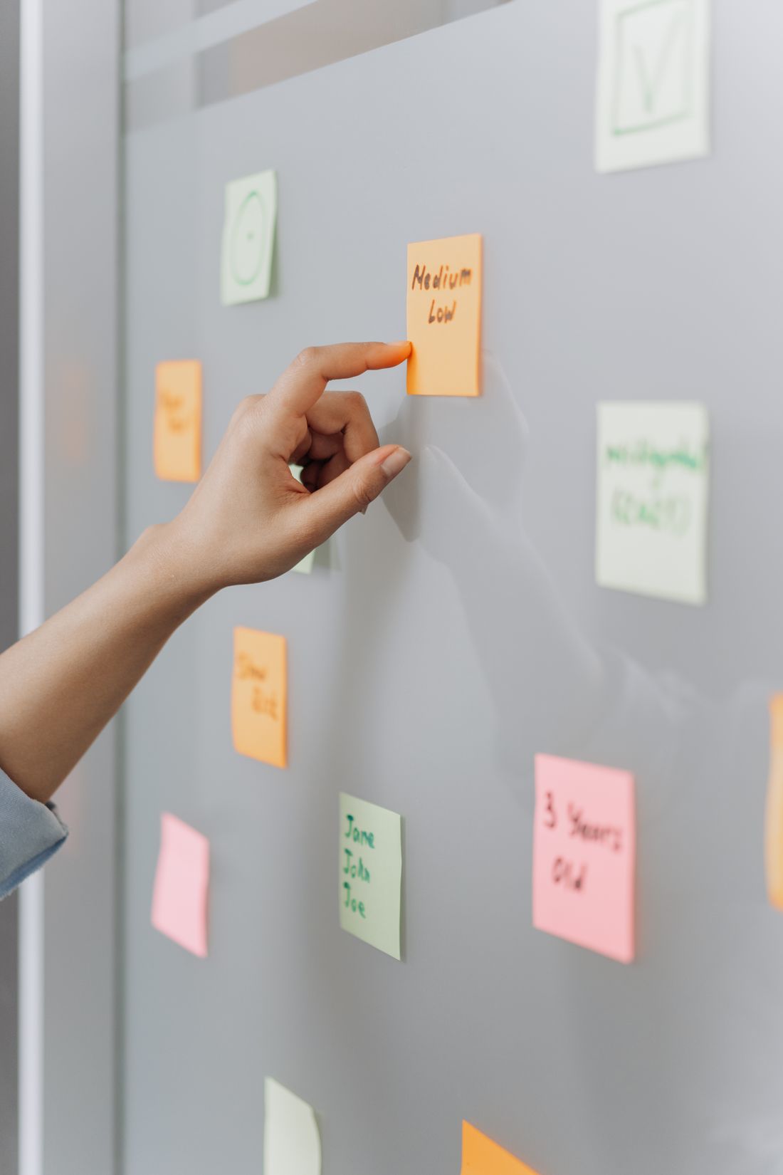 Person ordnet bunte Haftnotizen – Content-Ideen sammeln und sortieren.