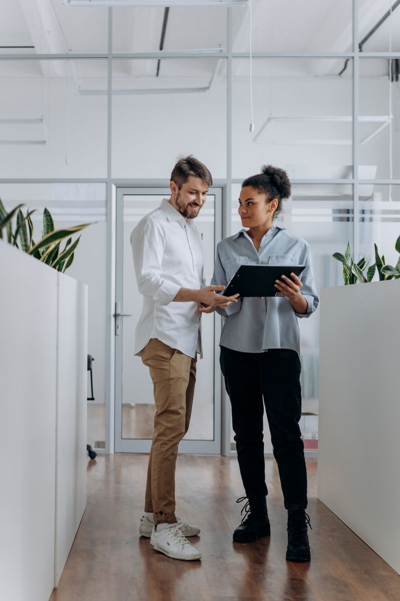 Professional team collaborating in modern office hallway