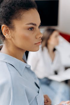 Professional young woman in corporate office environment, showcasing focus and determination.