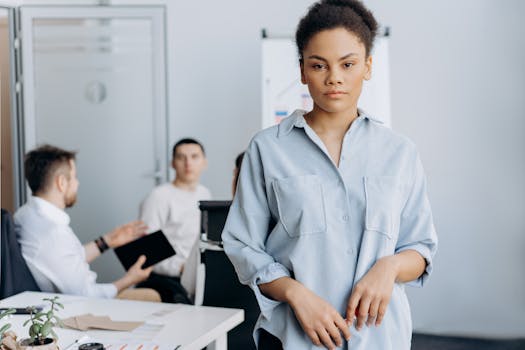 Young professional woman with colleagues in a corporate office environment.