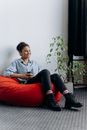 A Woman Sitting on the Red Beanbag
