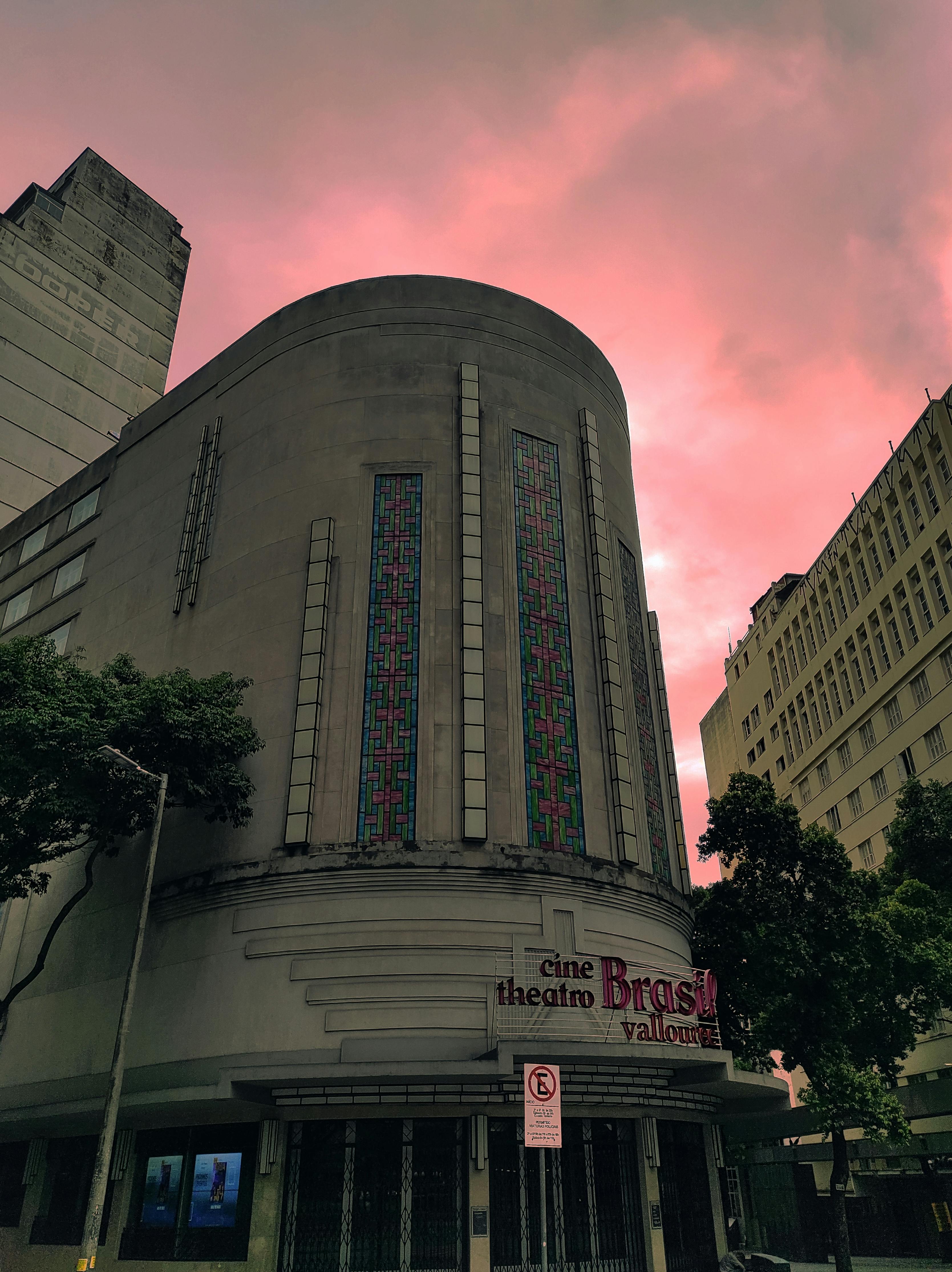 Free Artistic shot of an Art Deco theater under a striking pink sky, showcasing architectural elegance. Stock Photo