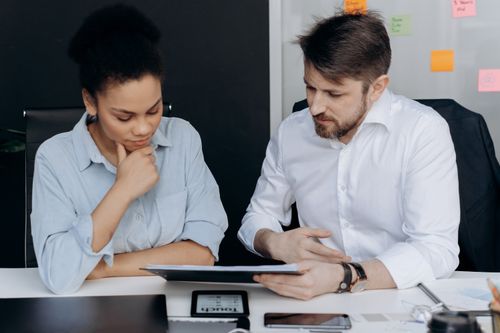 Free Two colleagues discussing project details in a modern office environment. Stock Photo