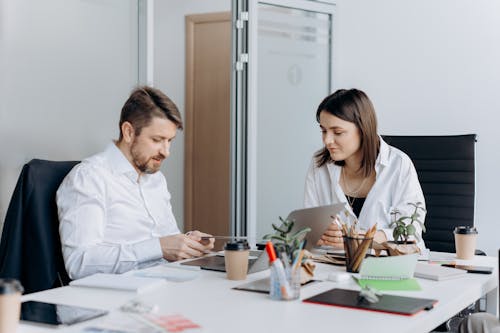 A Man and a Woman Sitting Inside a Meeting Room