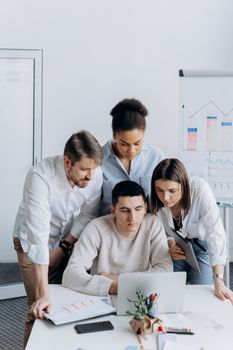 Diverse group of colleagues collaborating on a project in a modern office setting.