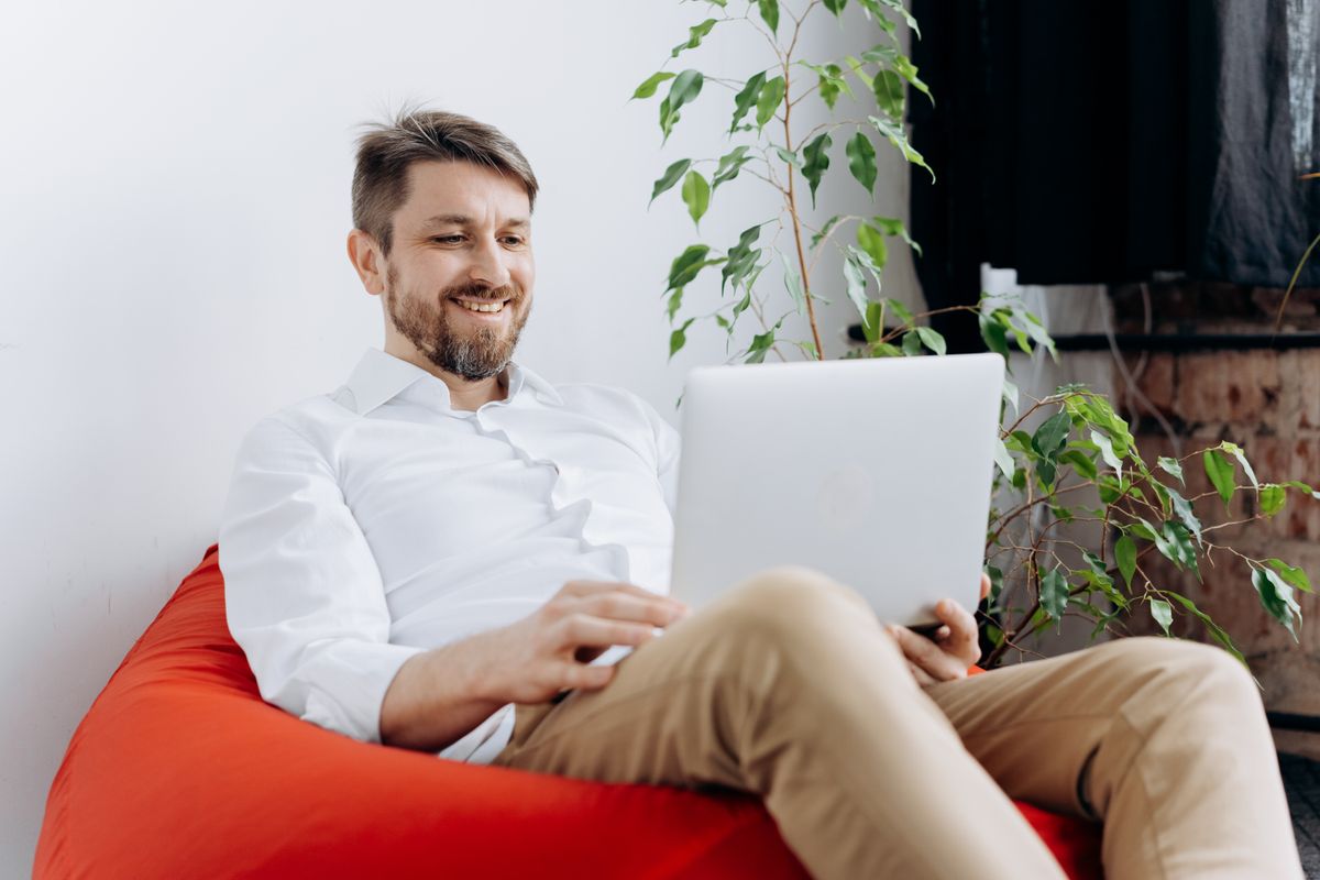 A relaxed person happily working on a laptop, making slides without paying for software