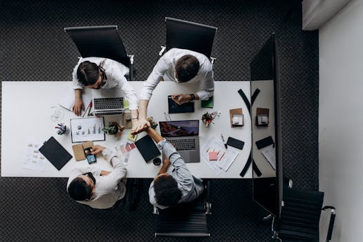 High angle view of colleagues collaborating around a conference table in a modern office setting.